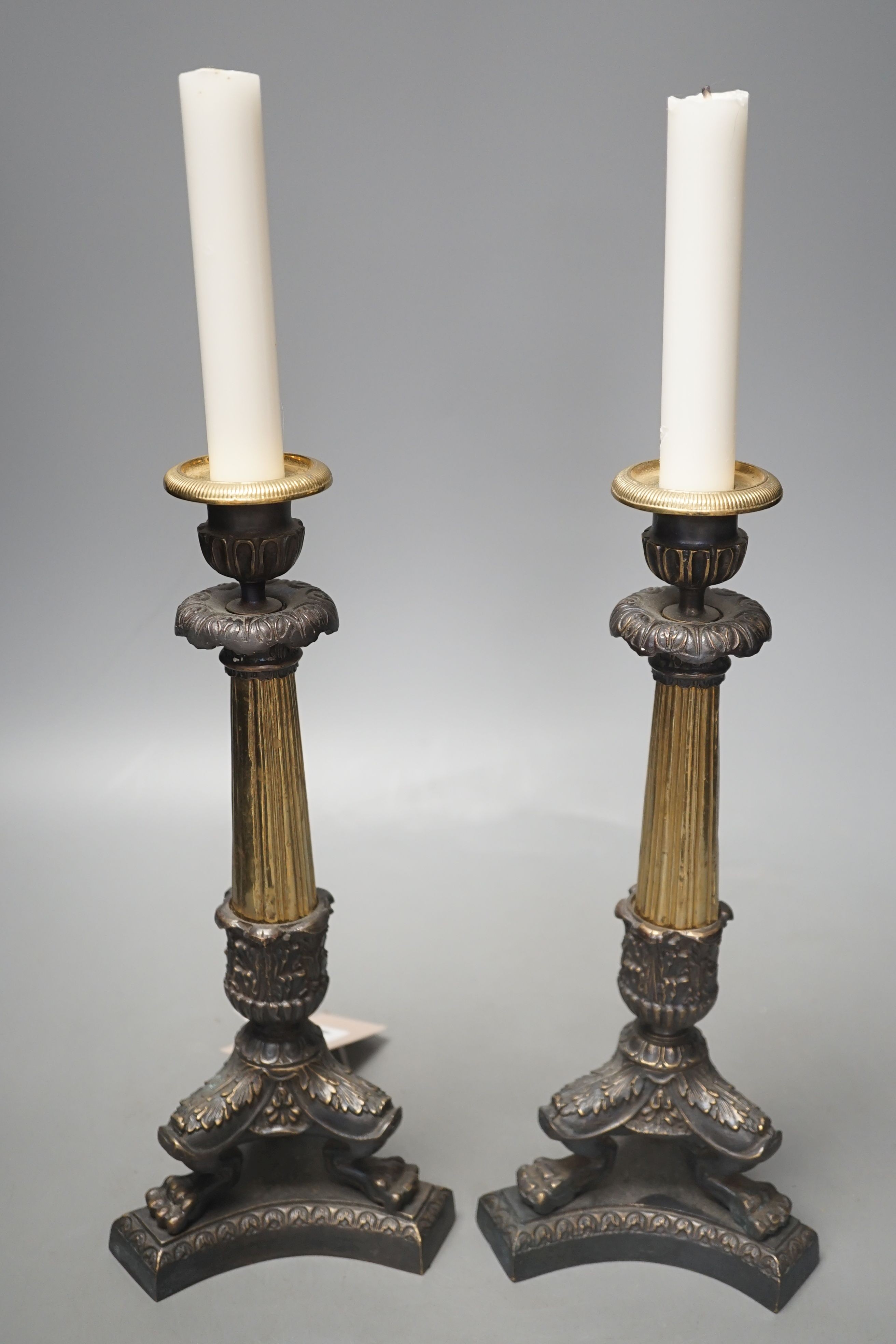 A pair of neo-classical style brass candlesticks, 28.5 cms high.